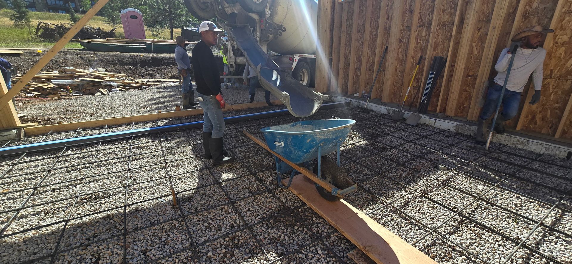 Construction worker pouring concrete into rebar on a building foundation site