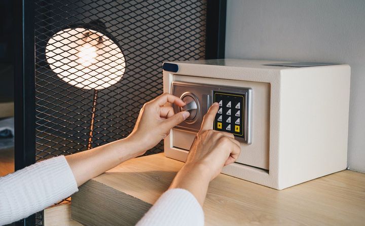 Hands entering a code on a digital safe — local locksmith