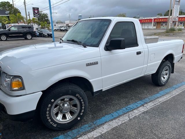 White pickup truck parked in a lot on a rainy day