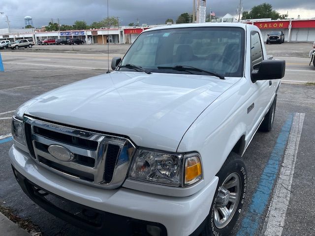 White pickup truck parked in a lot under cloudy skies