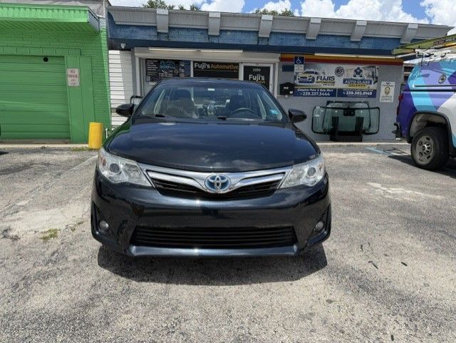 Black Toyota sedan parked in front of a building with a green garage door