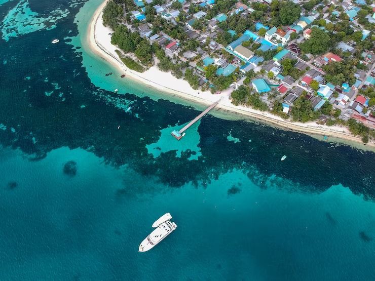 Una vista aérea de una isla tropical con un barco en el agua.