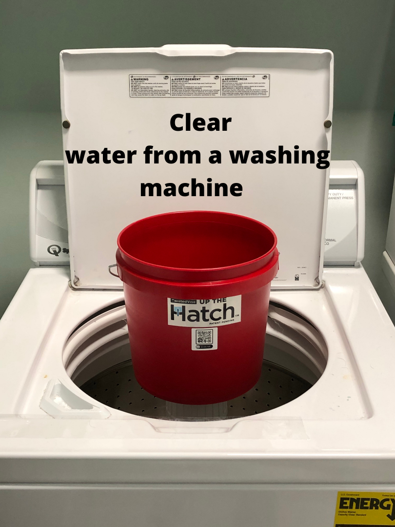 Red bucket under washing machine spout collecting clear water from the open washer lid