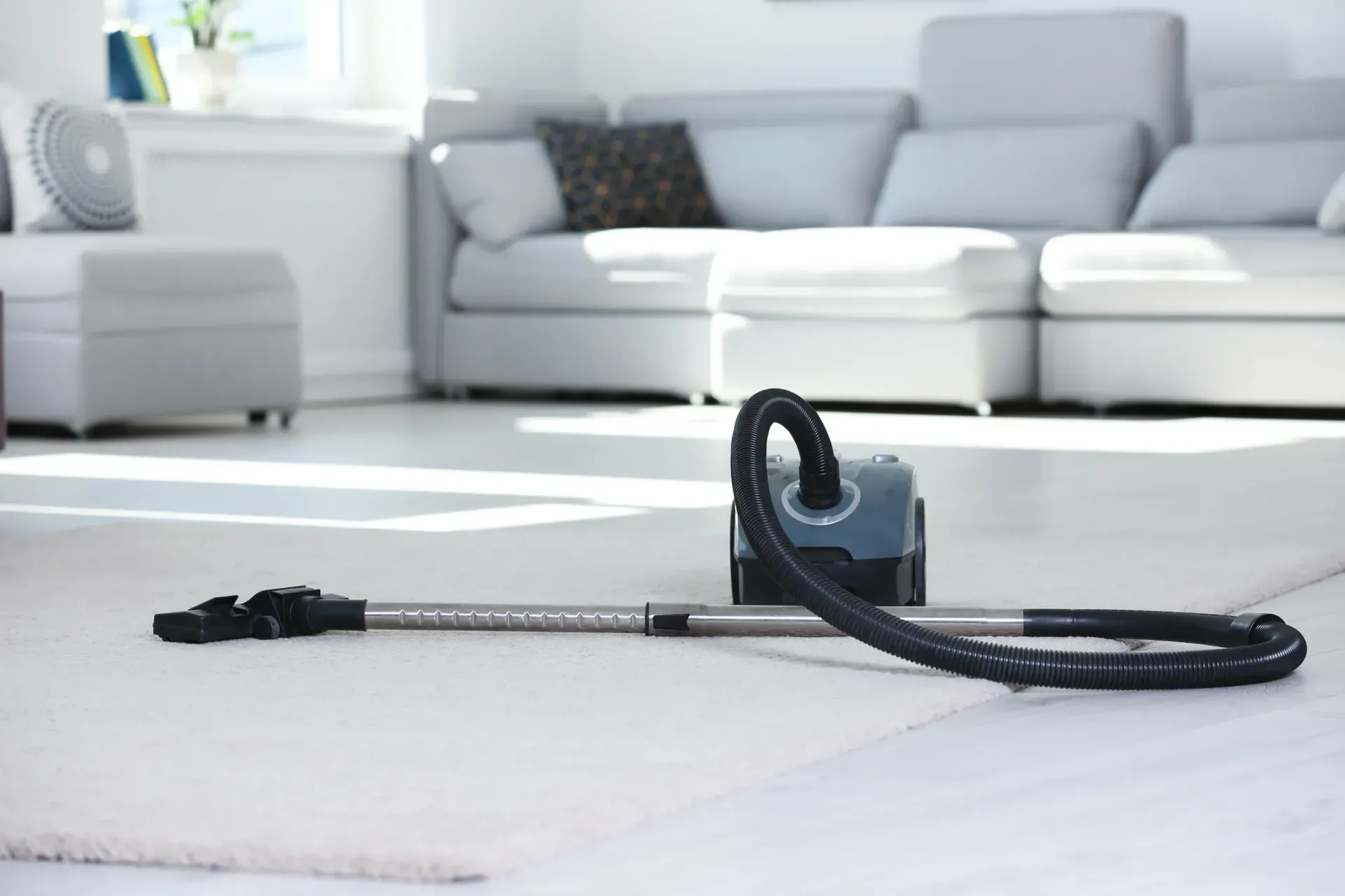 A vacuum cleaner is laying on the floor in a living room.