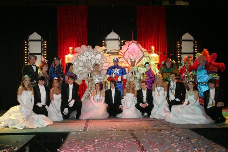 A group of people posing for a picture on a stage including captain america