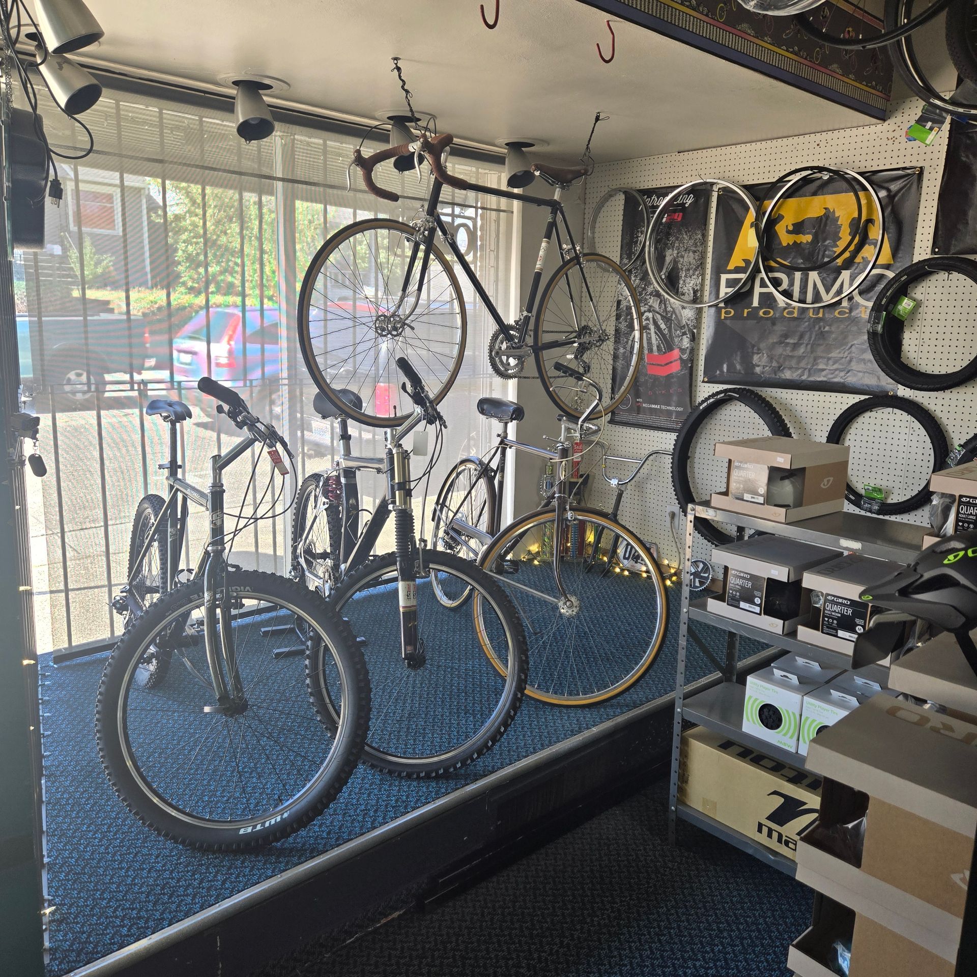 Several bicycles are displayed in a store with a sign that says prim