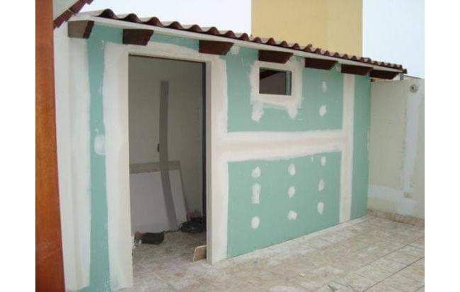 Pequeño edificio de color turquesa y blanco con techo de chapa ondulada