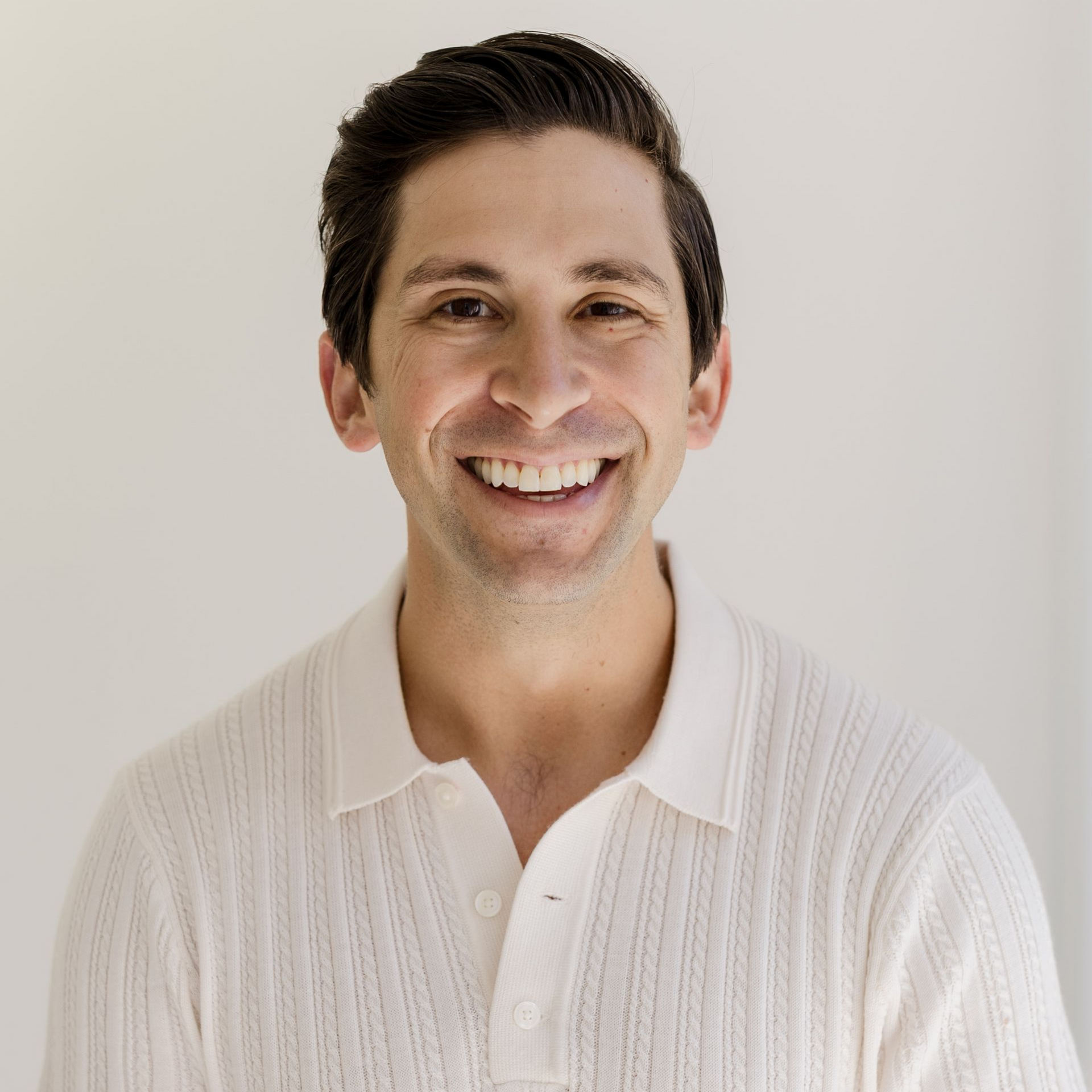 Smiling person in a white textured shirt against a light background