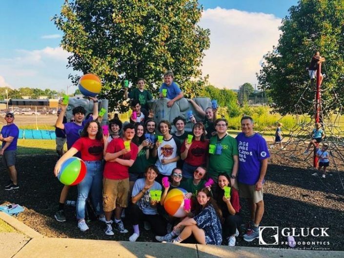 A group of people posing for a picture with a gluck logo in the corner