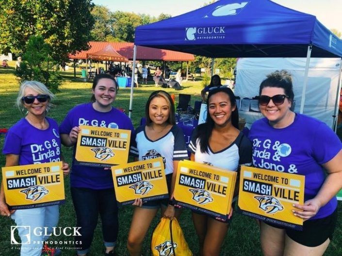 A group of women holding signs that say welcome to smashville