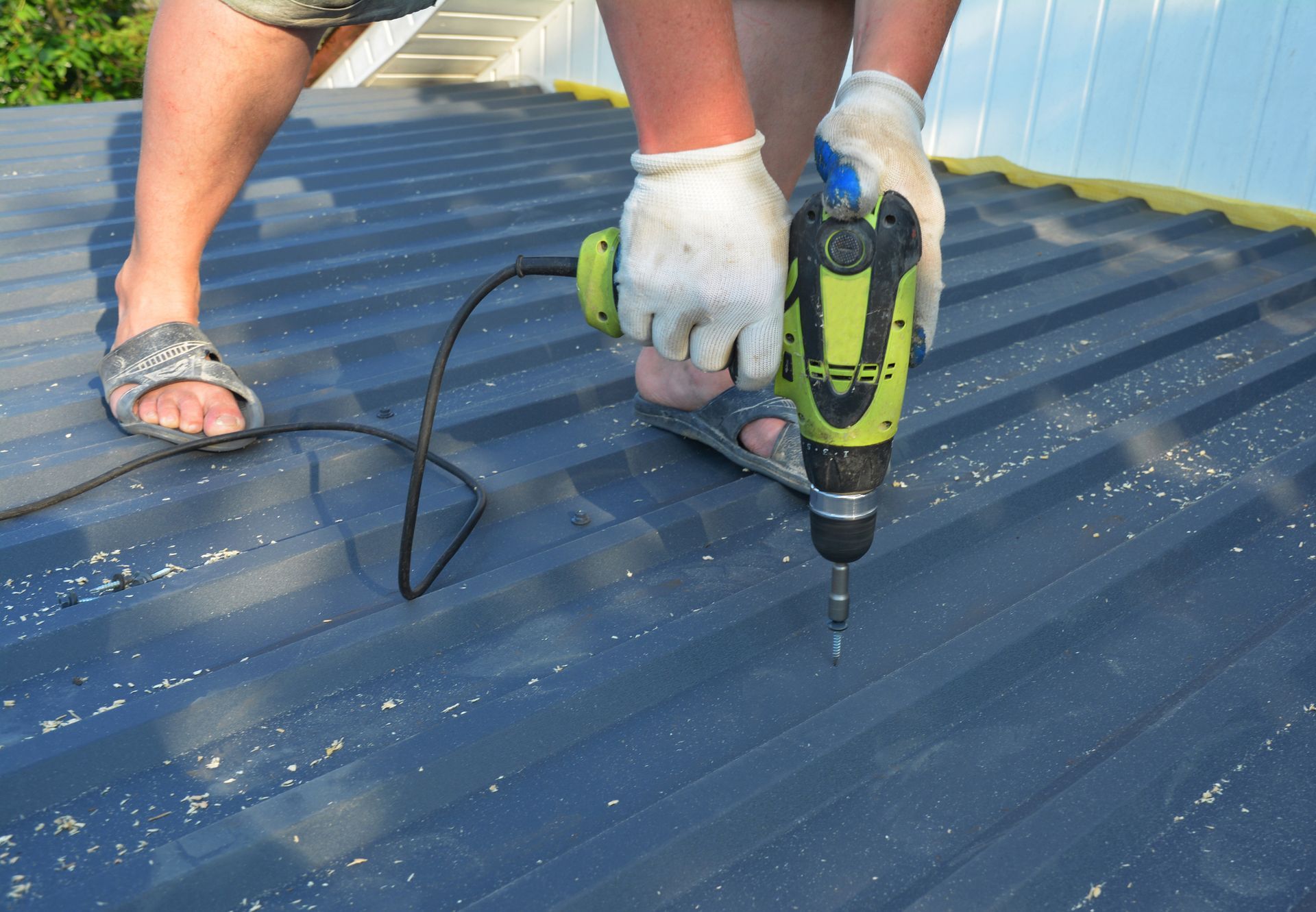 Person using a drill on a roof Person using a drill on a roof