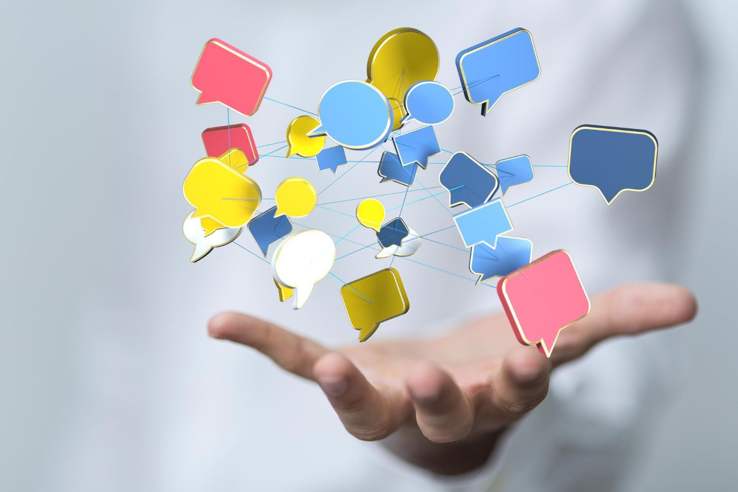 Hand holding up colorful speech bubbles connected by lines.
