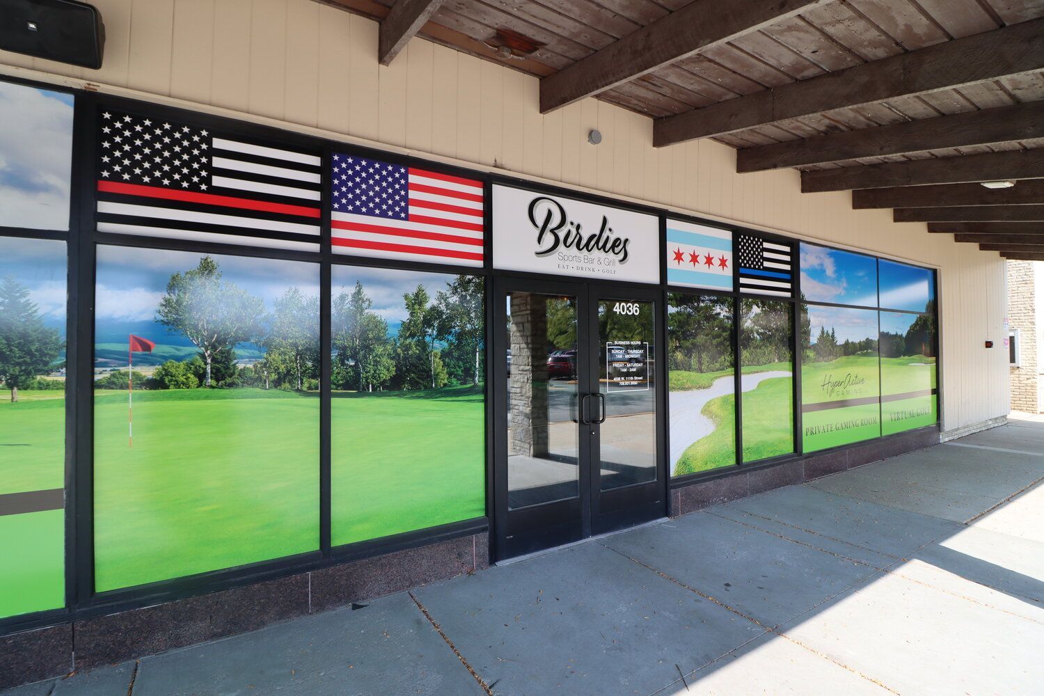 A building with a lot of windows has a picture of a golf course on the windows.