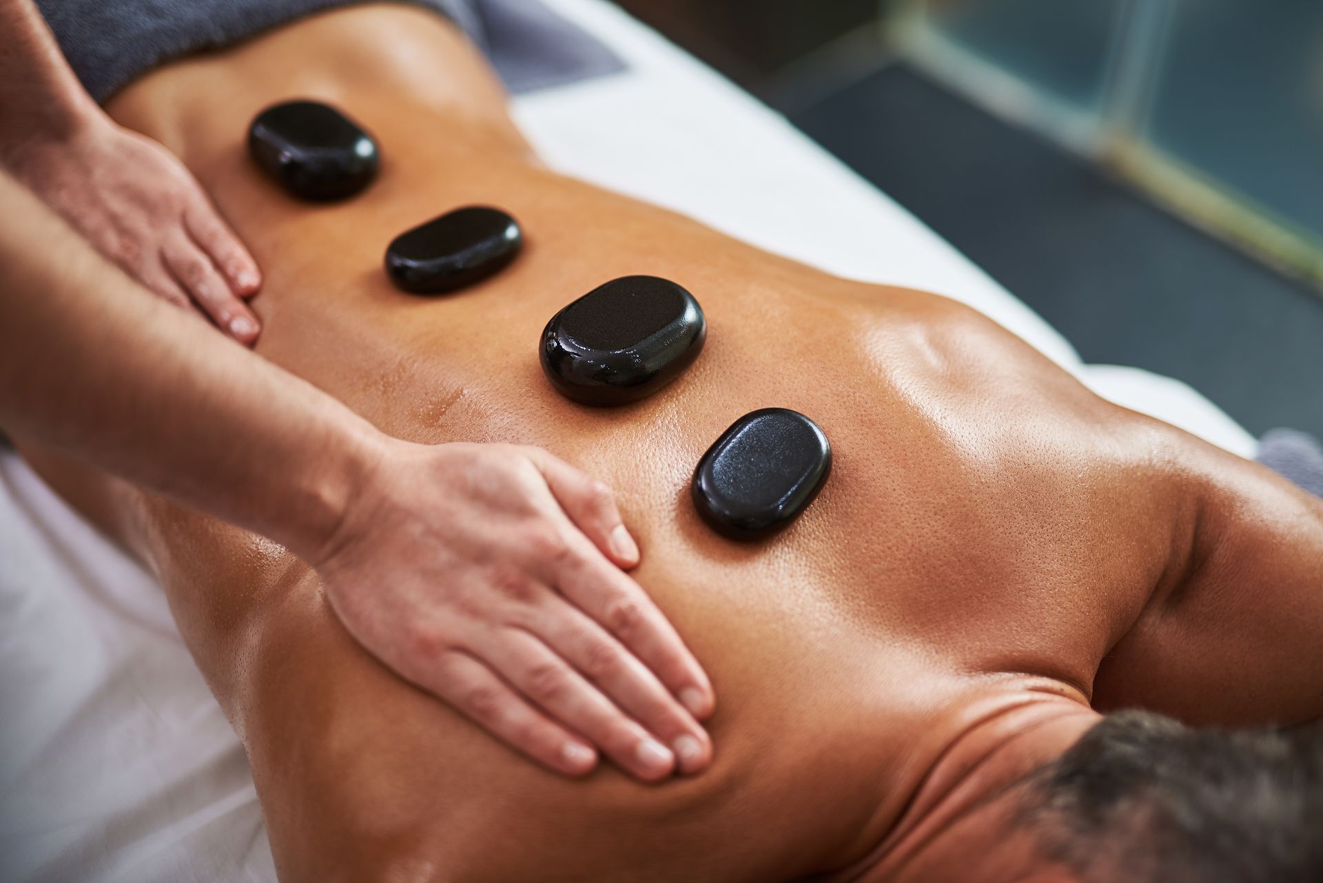 A Man is Getting a Hot Stone Massage at a Spa