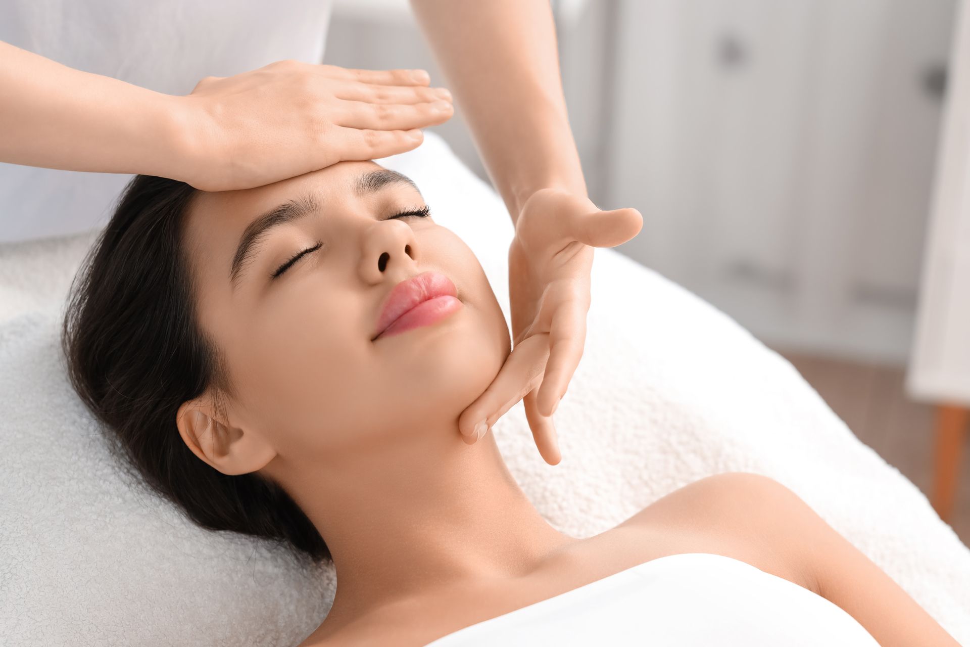 A Woman is Getting a Facial Massage at a Spa