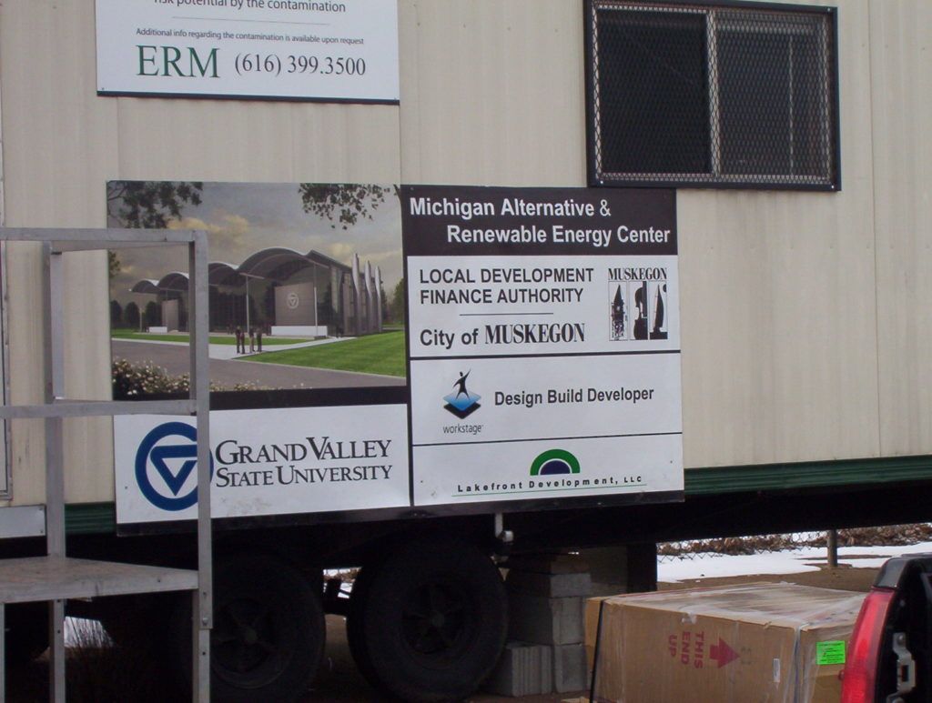 University trailer with signs for a local recovery clinic and Grand Valley State University loaded with boxes