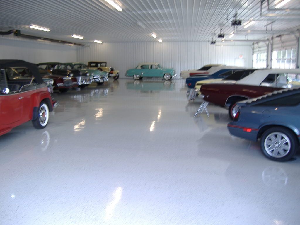 Bright car showroom with classic and modern cars arranged on a glossy white floor