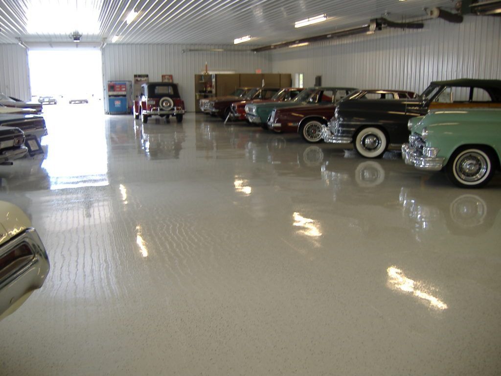 Indoor car showroom with several classic cars lined up on a glossy floor