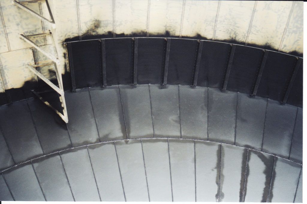 Curved black and gray metal panels lining the inside of a cylindrical industrial structure.