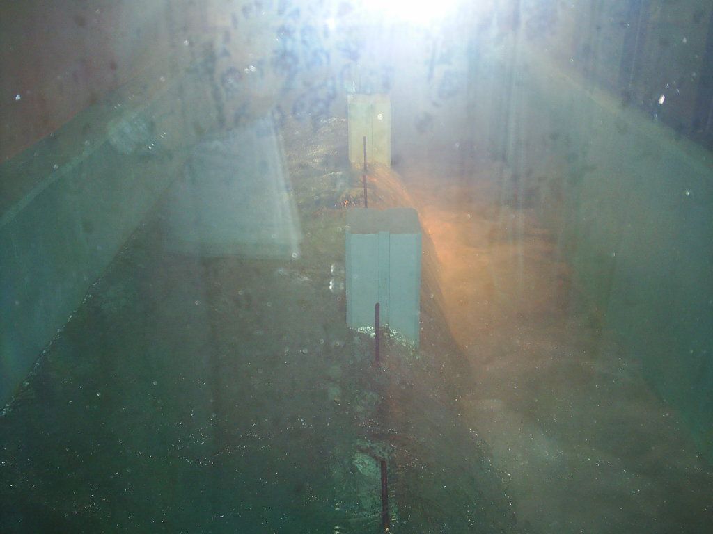 Blurry indoor scene with bright glare, a central sign, and a narrow walkway or corridor in dim light
