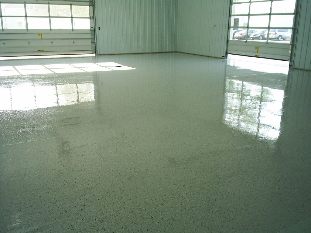 Empty bright room with glossy speckled floor and large windows reflecting light