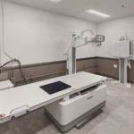 Modern medical imaging room with an X-ray table and wall-mounted equipment
