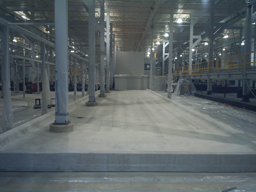 Empty industrial warehouse interior with steel columns and concrete floor under construction