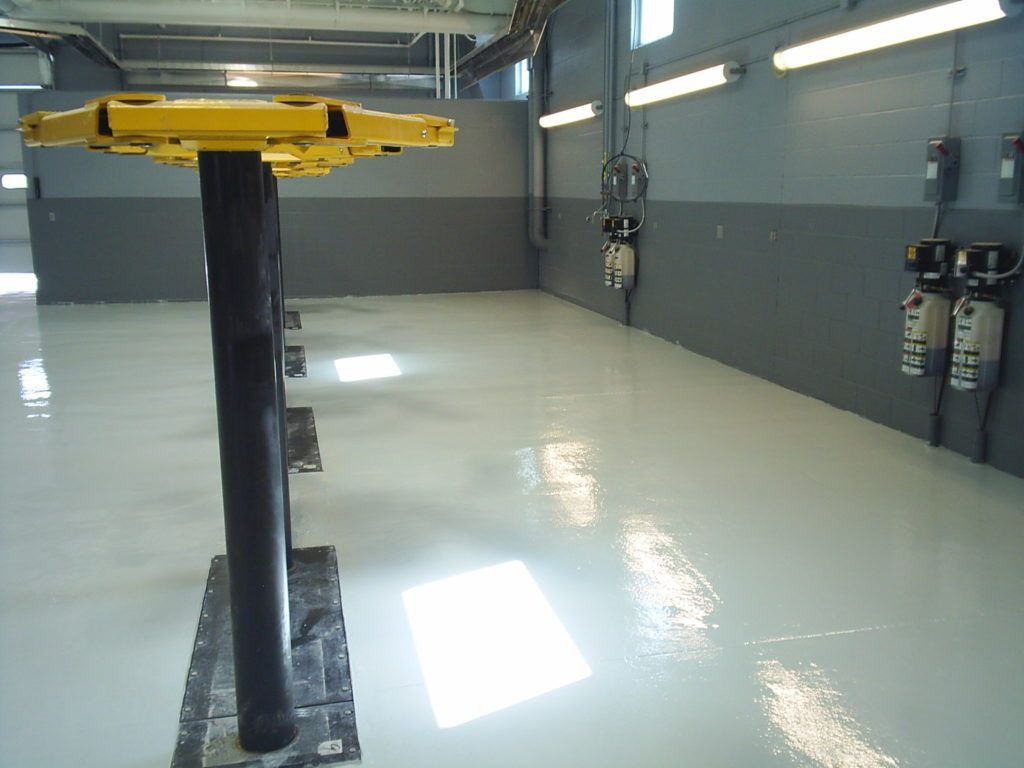 Industrial room with a glossy white floor and a yellow lift column in the center