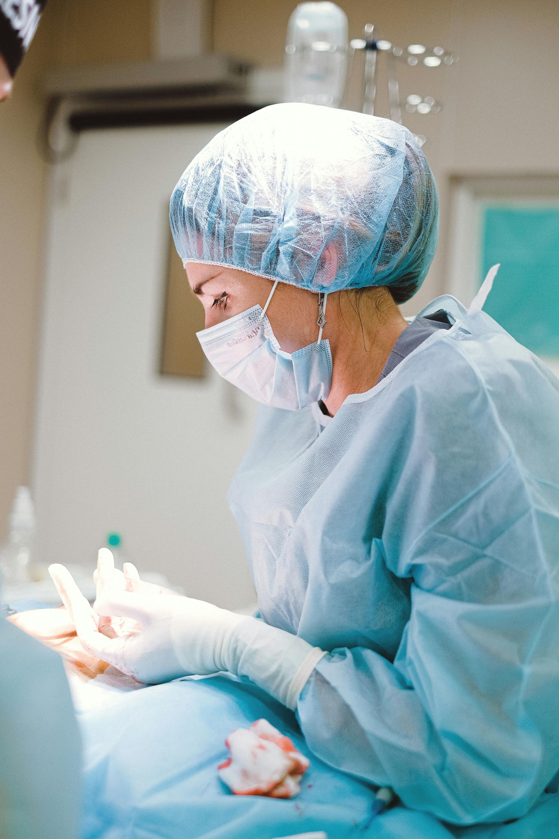 A female surgeon is operating on a patient in an operating room.