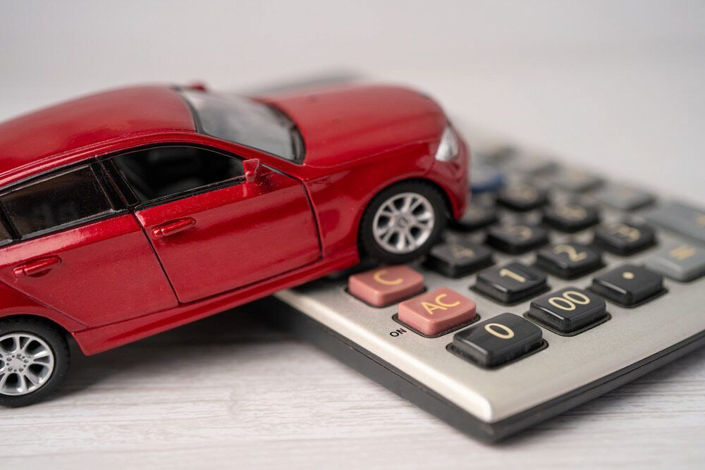 Red Toy Car Partially on a Calculator  — Fulgi's South Coast Automotive and Dismantling in Nowra, NSW