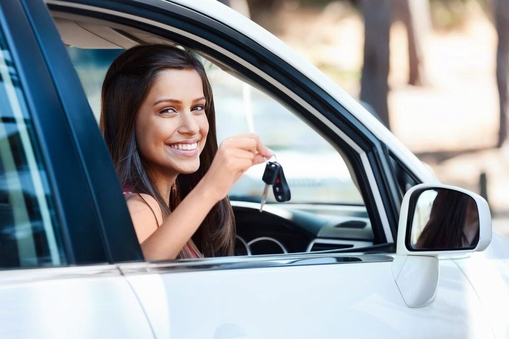 Woman in White Car Smiling, Holding Car Keys — Fulgi's South Coast Automotive and Dismantling in Campbelltown, NSW