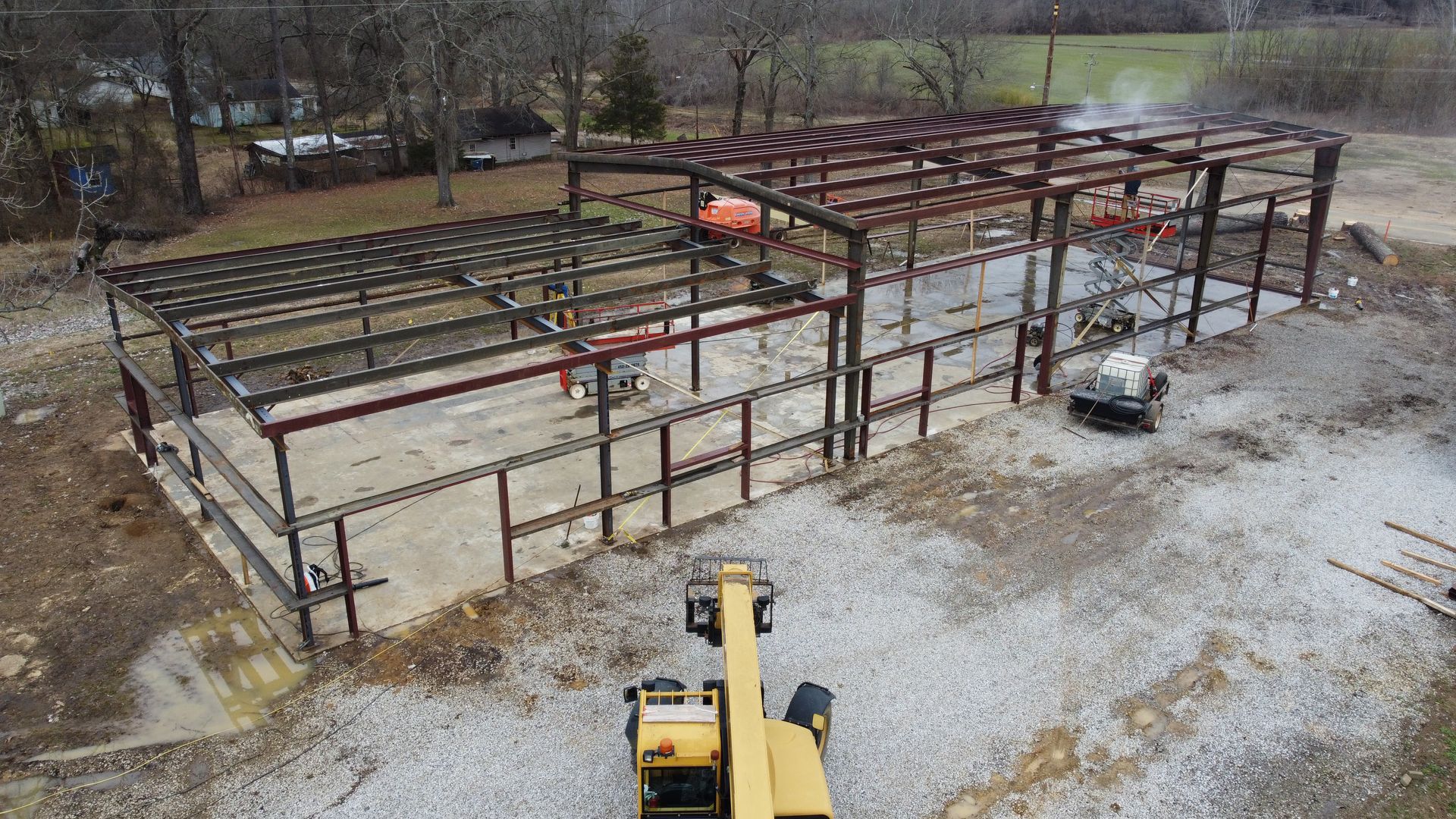 An aerial view of a building under construction with a crane in the foreground.