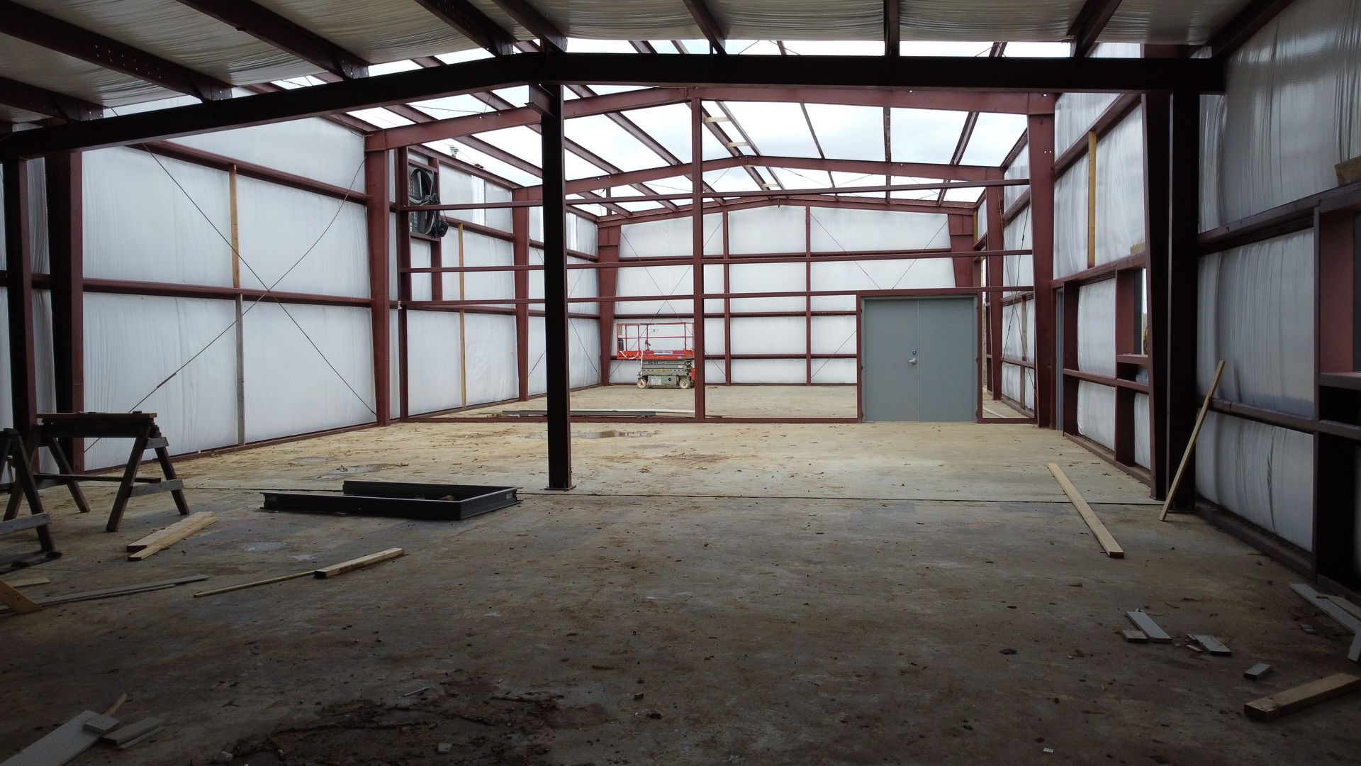 A large empty building with a metal frame and white walls