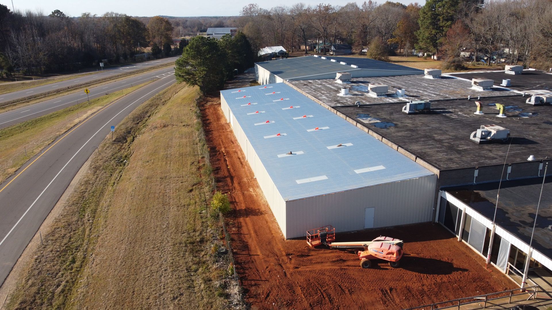 An aerial view of a large building next to a highway.
