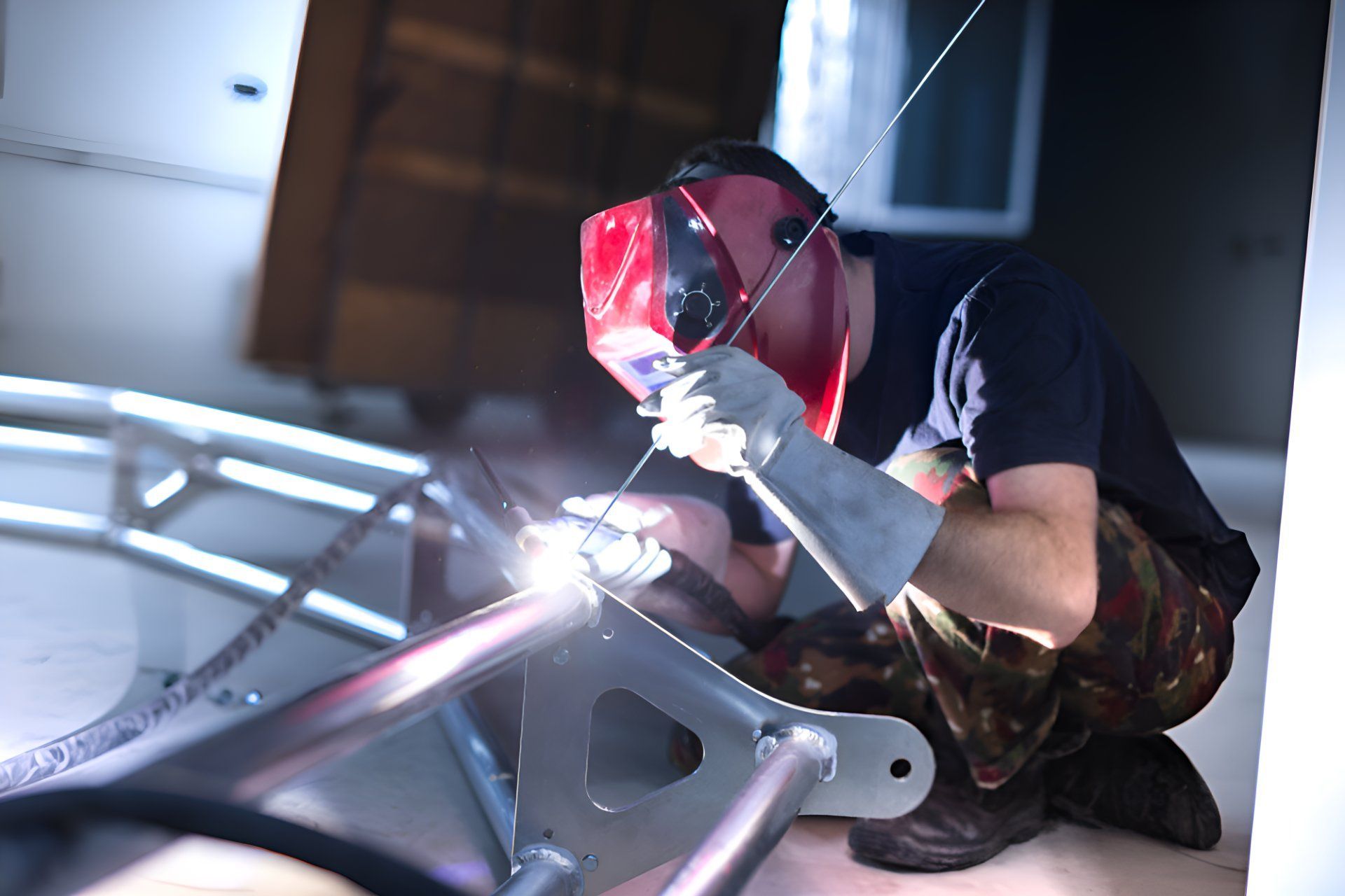 A Man Wearing A Welding Mask Is Welding A Piece Of Metal — Sno's Welding In Ciccone, NT