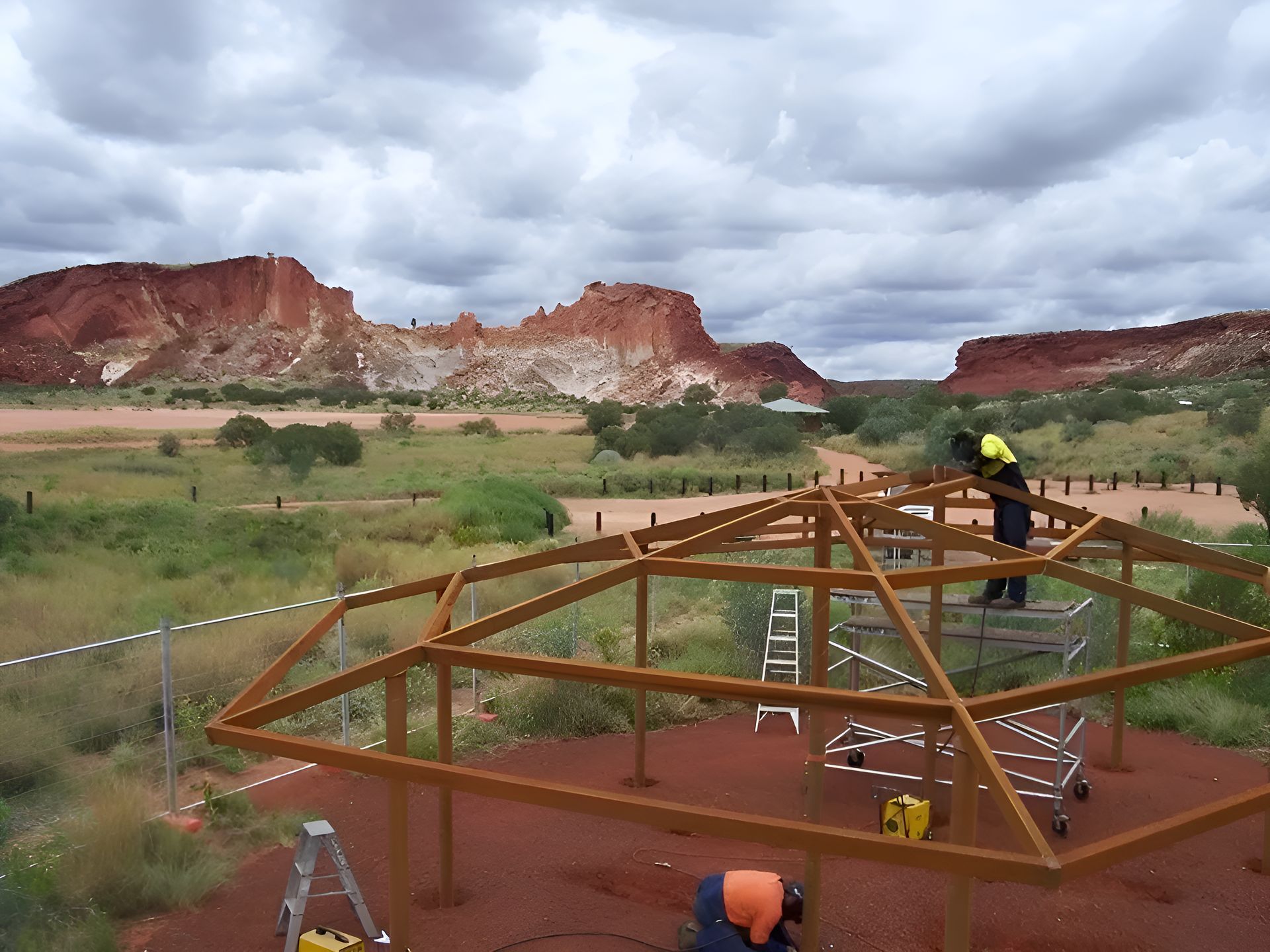 A Man Is Working On A Wooden Structure In The Desert — Sno's Welding In Ciccone, NT