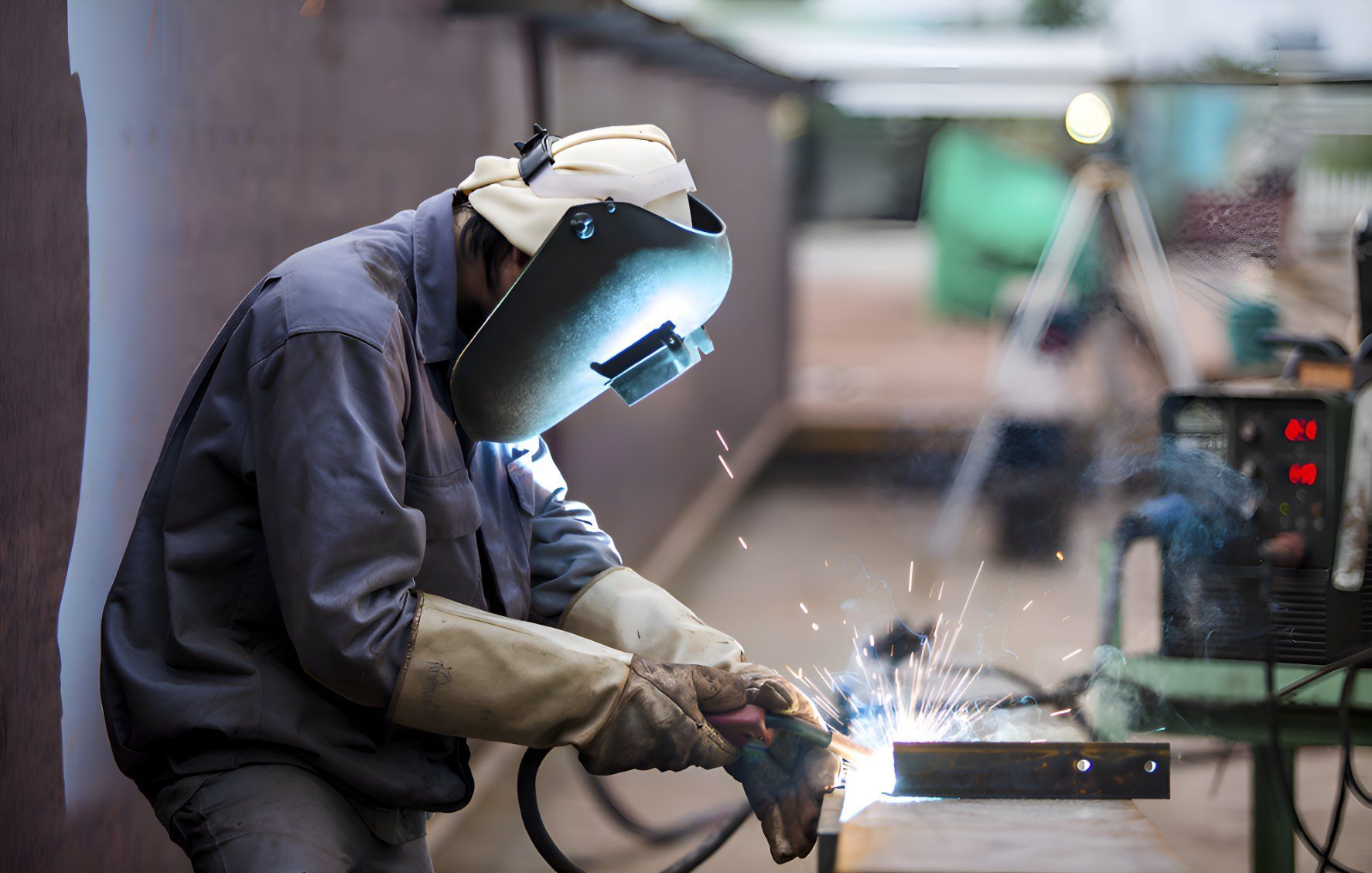 A Man Wearing A Welding Mask Is Welding A Piece Of Metal — Sno's Welding In Ciccone, NT