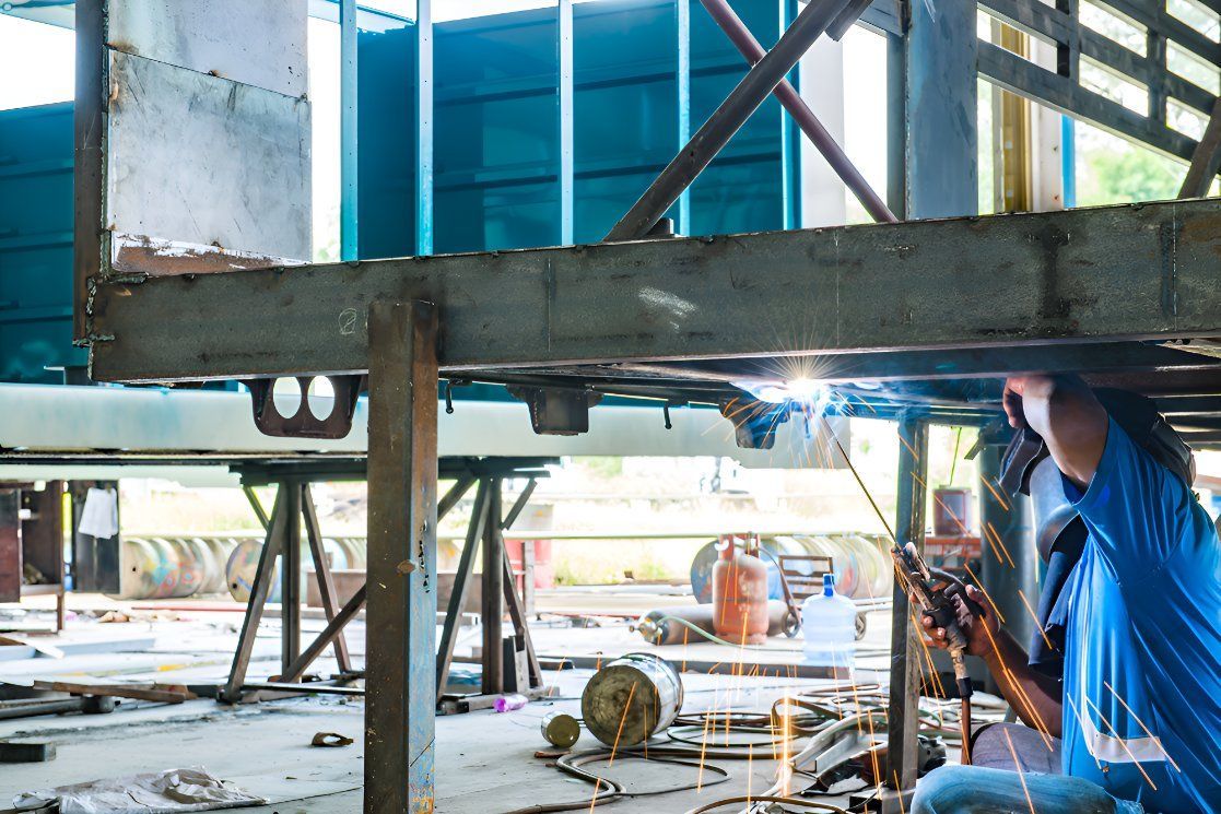 A Man Is Welding A Metal Structure In A Factory — Sno's Welding In Ciccone, NT