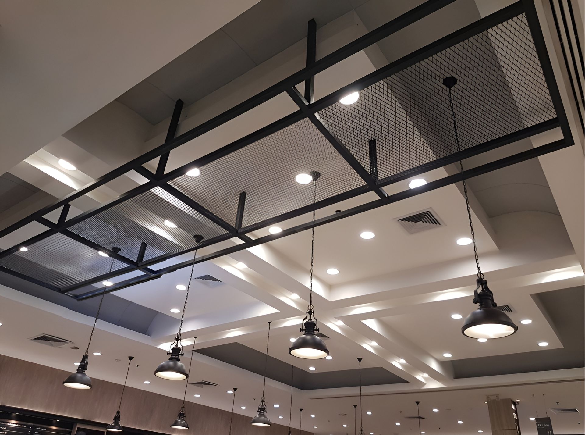 Ceiling with Black Metal Grid and Hanging Pendant Lights in A Modern Indoor Space — Bes-Elect Electrical in Taminda, NSW