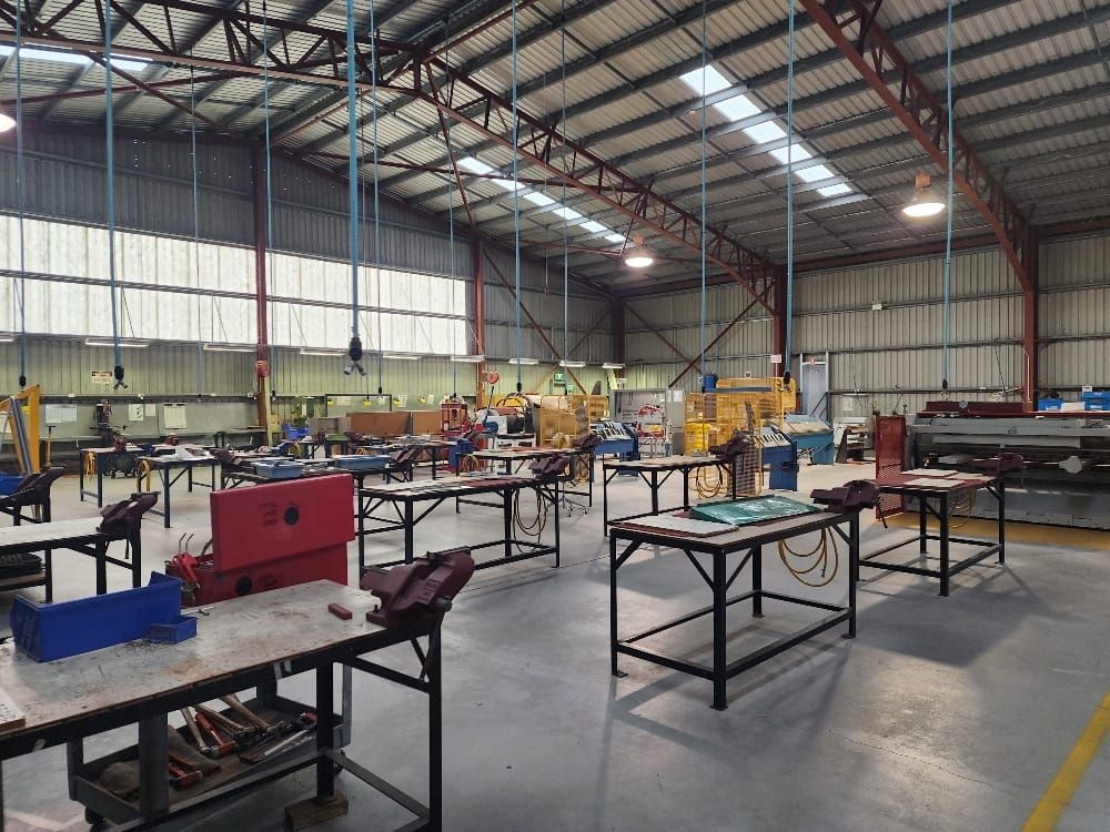 Large Industrial Workshop with Tables and Machinery Under Bright Overhead Lights — Bes-Elect Electrical in Taminda, NSW