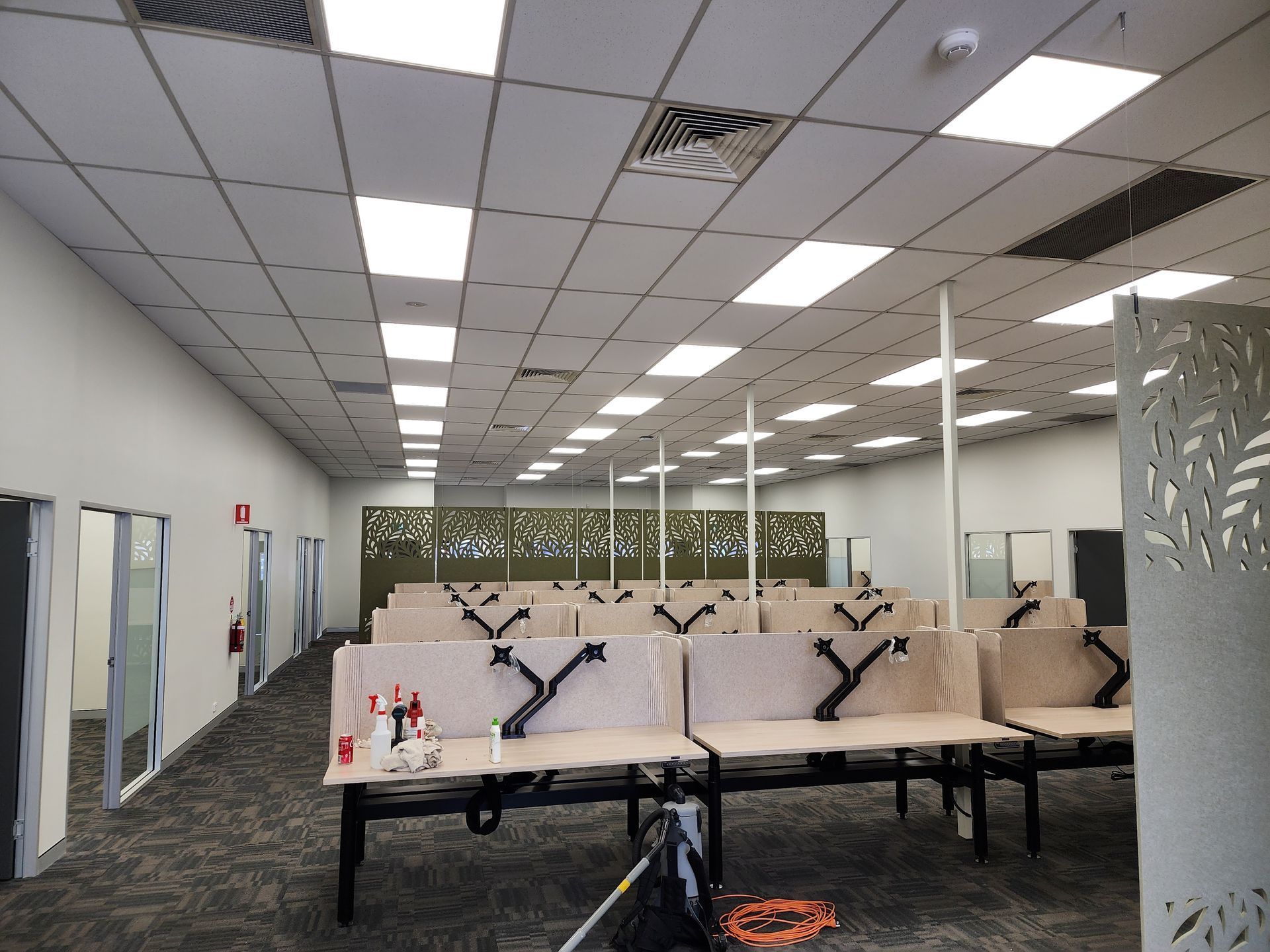 Empty Office with Rows of Desks and Ceiling Lights in A Carpeted Workspace — Bes-Elect Electrical in Taminda, NSW