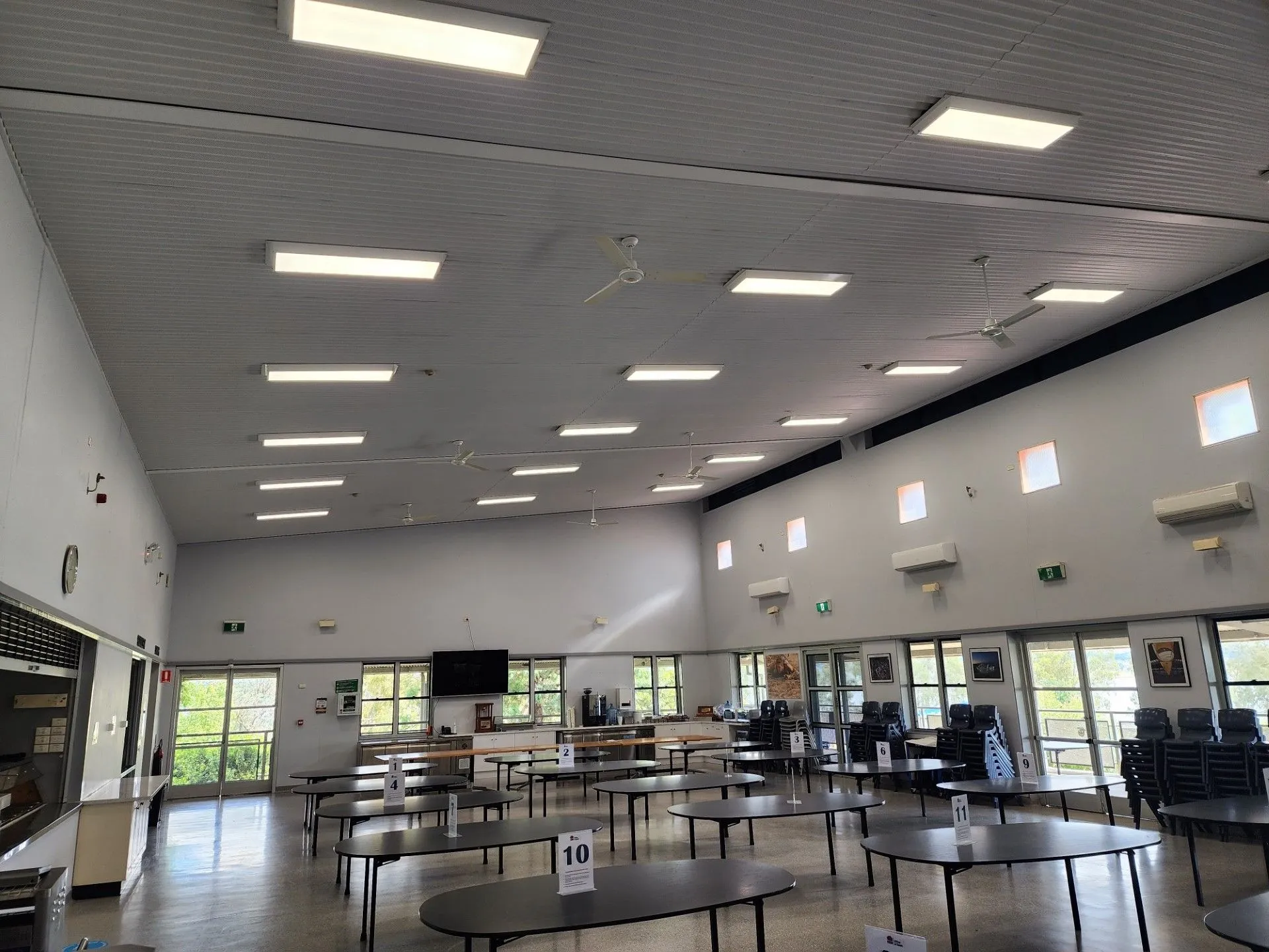 Empty Community Hall with Rows of Round Tables and Bright Ceiling Lights — Bes-Elect Electrical in Taminda, NSW