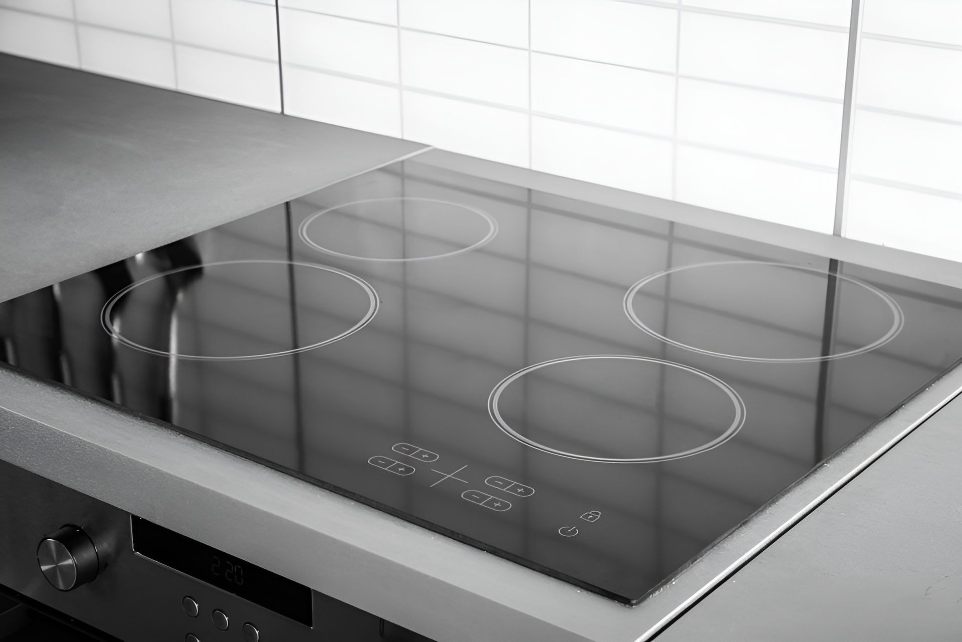 Black Glass Electric Cooktop with Four Burner Rings on A Kitchen Counter — Bes-Elect Electrical in Taminda, NSW