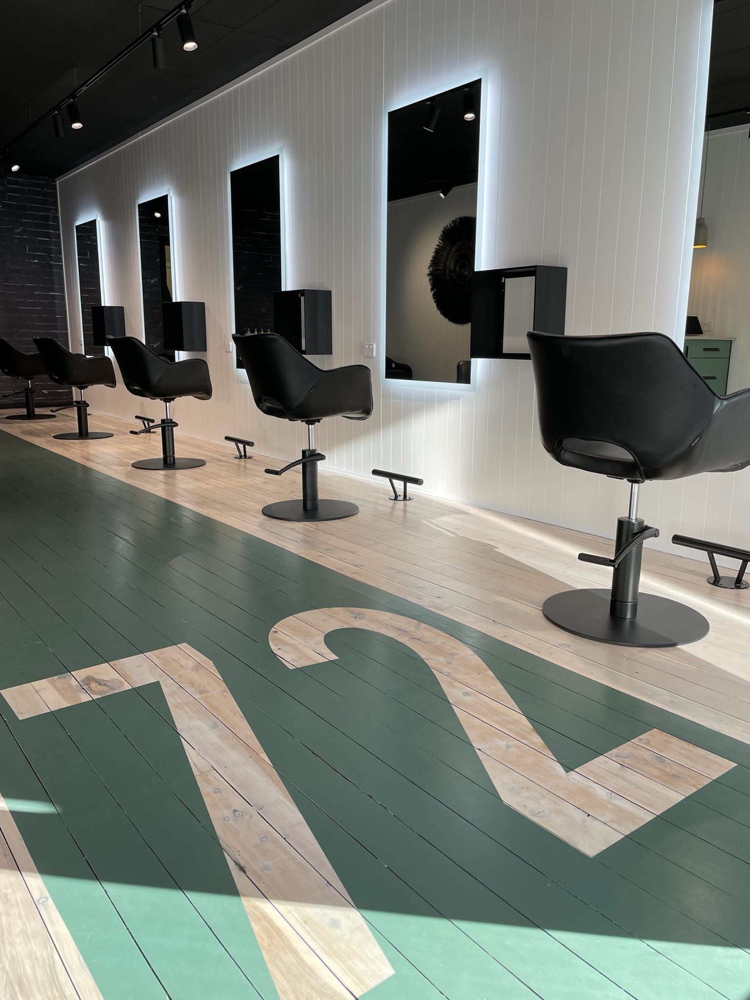 Modern Salon Interior with Black Chairs and Mirrors — Bes-Elect Electrical in Taminda, NSW