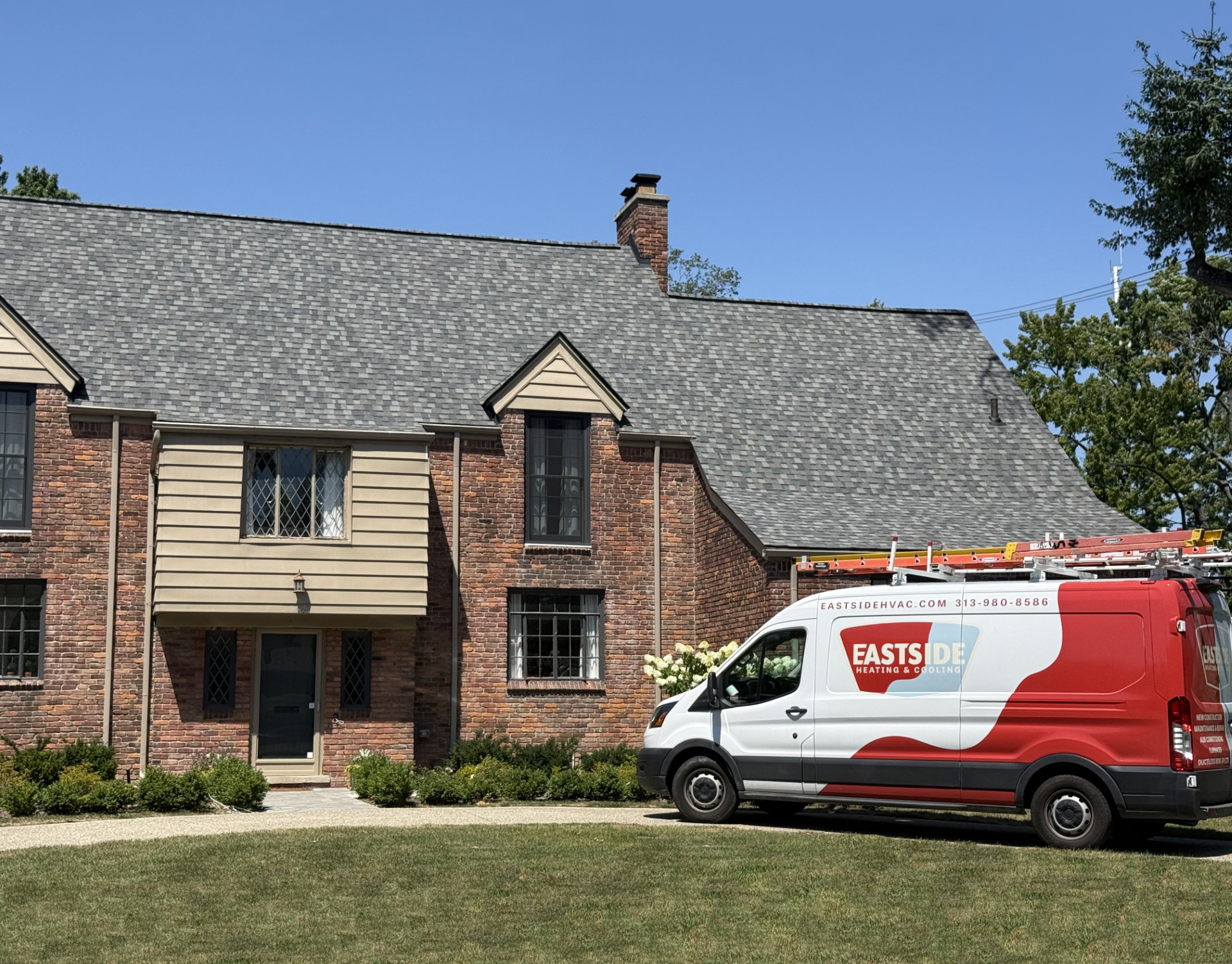 Red-and-white service van parked outside a brick apartment building under a clear blue sky. Red-and-white service van parked outside a brick apartment building under a clear blue sky.