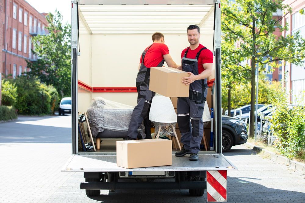 Two Men Are Loading Boxes Into A Moving Truck — South Burnett Truck Rental In Maryborough, QLD