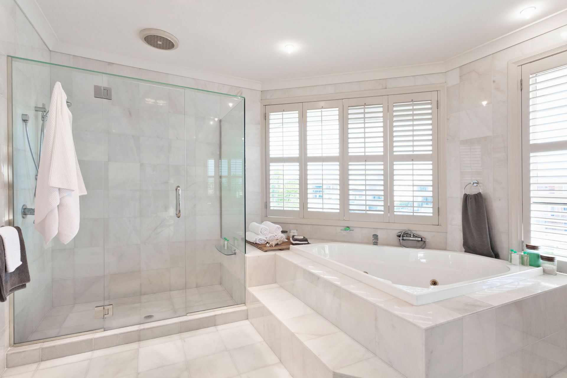 A bathroom with a tub, shower, and window.