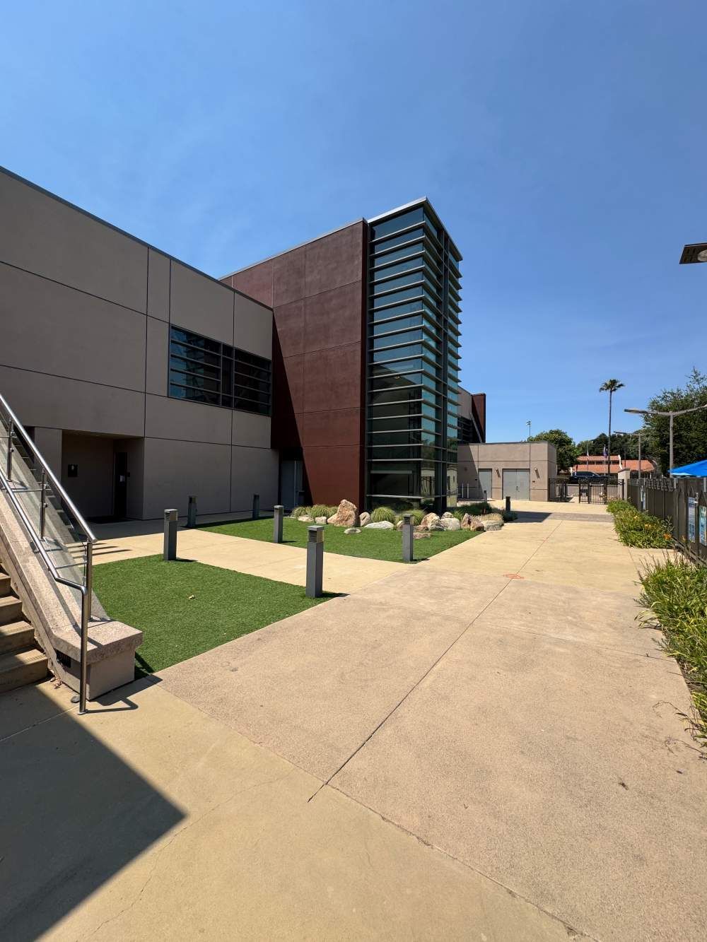 Outdoor campus walkway beside modern buildings under a clear blue sky