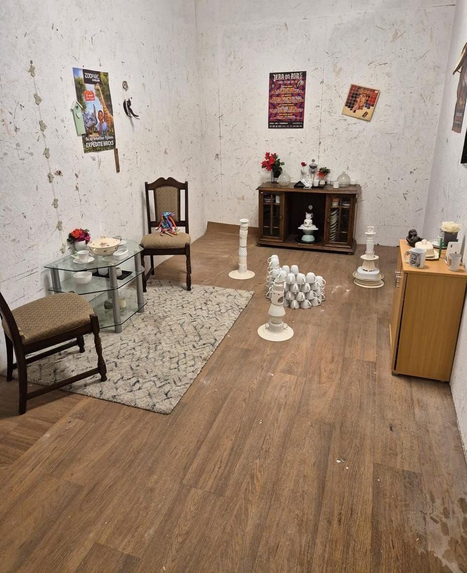 Een kamer met een kleed, meubels, ballonnen en een wereldkaart aan de muur.