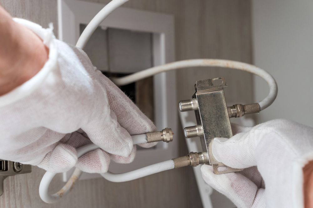 Worker inserts connector of a TV antenna — Level 2 Electrician Near Me in Lake Macquarie NSW